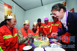 社區(qū)工作人員為集體過生日的三名環(huán)衛(wèi)工人點上生日蠟燭。 本報通訊員 趙松 攝
