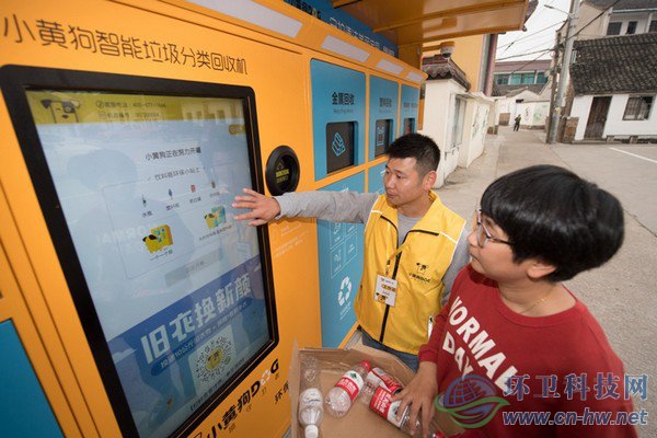10月30日，在道場鄉(xiāng)錢山下村，工作人員（左）指導(dǎo)村民在智能回收機上進行垃圾分類回收。